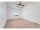 Bright bedroom with neutral carpet, ceiling fan, and large window at 5255 Memphis St # 219, Denver, CO 80239