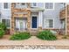 Charming townhome with stone accents, covered porch, and a vibrant blue front door at 219 at 5255 Memphis St # 219, Denver, CO 80239