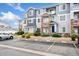 Exterior of blue townhouse with stone accents and parking spaces at 5255 Memphis St # 219, Denver, CO 80239