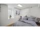 Finished basement bedroom featuring light-colored walls, plush gray bedding, and a window at 766 Fulton Ave, Brighton, CO 80601