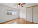 Bright bedroom featuring wood-look floors, white walls, window, ceiling fan, and closet at 766 Fulton Ave, Brighton, CO 80601