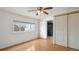 Bright bedroom featuring wood-look floors, white walls, a window, and a safe behind the closet door at 766 Fulton Ave, Brighton, CO 80601