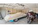 Well-lit garage featuring a covered car and a sleek motorcycle, maximizing space at 766 Fulton Ave, Brighton, CO 80601