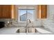Modern kitchen with a stainless steel sink, gray backsplash, and white countertops at 766 Fulton Ave, Brighton, CO 80601