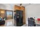Open kitchen layout with modern black refrigerator, adjacent dining area, and view into the sunlit living room at 766 Fulton Ave, Brighton, CO 80601