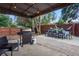 Cozy outdoor patio with dining table, BBQ, and hammock under a covered area and lush landscaping at 12292 W 65Th Ave, Arvada, CO 80004