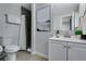 Modern bathroom featuring a shower with dark tile, a white vanity, and neutral wall art at 12292 W 65Th Ave, Arvada, CO 80004