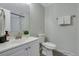 Bright bathroom featuring a white vanity, a shower with white tile, and neutral walls at 12292 W 65Th Ave, Arvada, CO 80004