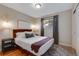 Comfortable bedroom with wood floors, king bed, and stylish bedside lighting fixtures at 12292 W 65Th Ave, Arvada, CO 80004
