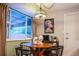 Bright breakfast nook with a round wooden table, pendant lighting, and an interesting art print at 12292 W 65Th Ave, Arvada, CO 80004