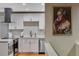 This stylish kitchen features white cabinets, stainless appliances, and an eye-catching piece of pop art at 12292 W 65Th Ave, Arvada, CO 80004