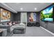 Finished basement with a cozy sectional sofa, movie posters, and large screen TV at 12292 W 65Th Ave, Arvada, CO 80004
