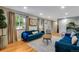Bright and airy living room with hardwood floors, large windows, and a blue sofa at 12292 W 65Th Ave, Arvada, CO 80004