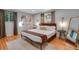 Well-lit main bedroom with wood floors, a king bed and decorative wall art at 12292 W 65Th Ave, Arvada, CO 80004