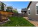 Green backyard with wooden fence, rock feature, and some small stone landscaping at 549 Tippen Pl, Castle Rock, CO 80104