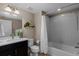 Bright bathroom with a white tiled shower/bathtub combo, black vanity, and decorative elements at 549 Tippen Pl, Castle Rock, CO 80104