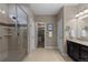 Bright bathroom featuring a glass enclosed shower, vanity with dark cabinets, and walk-in closet at 549 Tippen Pl, Castle Rock, CO 80104