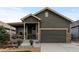 Charming single-Gathering home featuring a covered porch and a two-car garage with stone accents at 549 Tippen Pl, Castle Rock, CO 80104