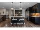 Kitchen featuring a granite island, stainless steel appliances, dark cabinets and adjacent dining area at 549 Tippen Pl, Castle Rock, CO 80104
