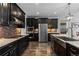 Well-appointed kitchen featuring dark cabinets, stainless steel appliances, granite countertops, and sleek hardwood floors at 549 Tippen Pl, Castle Rock, CO 80104