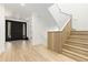 Welcoming foyer with hardwood floors, modern staircase, and black front door at 1919 Bellaire St, Denver, CO 80220