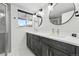 Modern bathroom featuring dual sinks, round mirrors, and updated fixtures with lots of natural light at 6495 E Happy Canyon Rd # 62, Denver, CO 80237