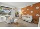 Charming Bedroom with a crib, rocking chair, and daisy accents creating a warm and inviting space at 6495 E Happy Canyon Rd # 62, Denver, CO 80237