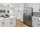 Bright kitchen featuring stainless steel fridge, white cabinetry, marble backsplash, and a breakfast bar at 6495 E Happy Canyon Rd # 62, Denver, CO 80237