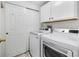 Bright laundry room with white washer and dryer, closet and overhead storage at 13028 Grant W Cir # A, Thornton, CO 80241