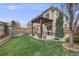 Backyard showing a lush lawn, wooden fence, and a covered patio area with table and chairs at 1311 Carlyle Park Cir, Highlands Ranch, CO 80129