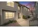 Inviting townhome showcases manicured landscaping, complemented by the warm hues of the sunset sky at 1311 Carlyle Park Cir, Highlands Ranch, CO 80129