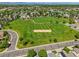 Aerial shot of the neighborhood park and the Woodglen Meadows Park sign surrounded by trees and greenery at 5154 E 126Th Ct, Thornton, CO 80241