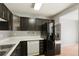 Kitchen with dark wood cabinets, stainless steel appliances, and a view into the living area at 5154 E 126Th Ct, Thornton, CO 80241