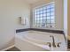 Soaking tub with a modern tile window that provides natural light and unique decor at 9523 Gray Ct, Westminster, CO 80031