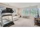 Bright living room features a comfortable sectional, a modern painting, and a treadmill, perfect for relaxation and fitness at 9523 Gray Ct, Westminster, CO 80031