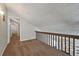 Cozy loft space with brown carpet, natural light, and railing overlooking the living room area at 9797 E Peakview Ave # C10, Englewood, CO 80111
