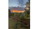 Views of sunset in the backyard with a well-maintained lawn and privacy fence at 12693 W 82Nd Ln, Arvada, CO 80005