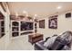 Basement entertainment room featuring a large TV, built in display shelves and a leather couch at 12693 W 82Nd Ln, Arvada, CO 80005