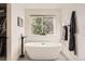Bright bathroom with a stand-alone tub under a large window and a walk-in closet on the side at 12693 W 82Nd Ln, Arvada, CO 80005