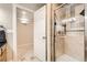 Tiled bathroom featuring a glass-enclosed shower and adjoining walk-in closet at 12693 W 82Nd Ln, Arvada, CO 80005
