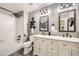 Industrial style bathroom with double vanity sink, mirrors, and shower with dark hardware at 12693 W 82Nd Ln, Arvada, CO 80005