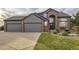 Beautiful brick and gray two-story home with a three-car garage and well-manicured lawn at 12693 W 82Nd Ln, Arvada, CO 80005