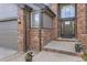 Welcoming front entrance with beautiful brick accents and a three-car garage at 12693 W 82Nd Ln, Arvada, CO 80005