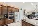 View of the kitchen with stainless appliances, granite counters, tile backsplash, and access to the stairs and living room at 12693 W 82Nd Ln, Arvada, CO 80005