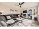 Comfortable living room with a dark leather sofa, fireplace, built-in shelves, and a ceiling fan at 12693 W 82Nd Ln, Arvada, CO 80005