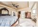 Bright main bedroom with neutral walls, tray ceilings, a ceiling fan, light carpet, and dark wood furniture at 12693 W 82Nd Ln, Arvada, CO 80005