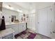 Bright bathroom features a double sink vanity, glass enclosed shower and stylish purple rug at 14670 Guernsey Dr, Mead, CO 80542