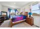 Inviting bedroom with natural light, colorful bedding, two windows, and tasteful decor at 14670 Guernsey Dr, Mead, CO 80542
