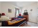 Cozy bedroom with a colorful quilt, a dresser, and a window providing natural light and a comfortable retreat at 14670 Guernsey Dr, Mead, CO 80542