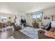 Open-concept living room featuring a comfortable seating area, large windows with natural light, and seamless flow to the dining area at 14670 Guernsey Dr, Mead, CO 80542
